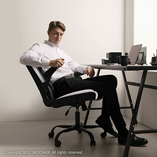 Man sitting on office chair at desk