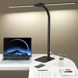 Sleek desk lamp with a laptop and smartphone on a white desk.